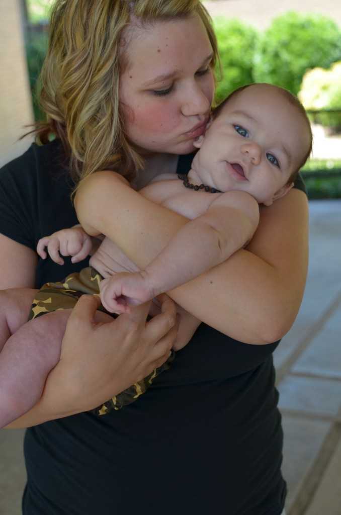 Oxytocin the Love HormoneBlonde women holding her 6 month old baby boy and leaning in to kissing her baby.