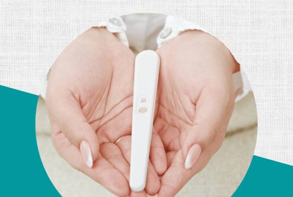 Text: Preparing for pregnancy Image: A woman is has her hands laying on top of each other and she is holding out a positive pregnancy test.